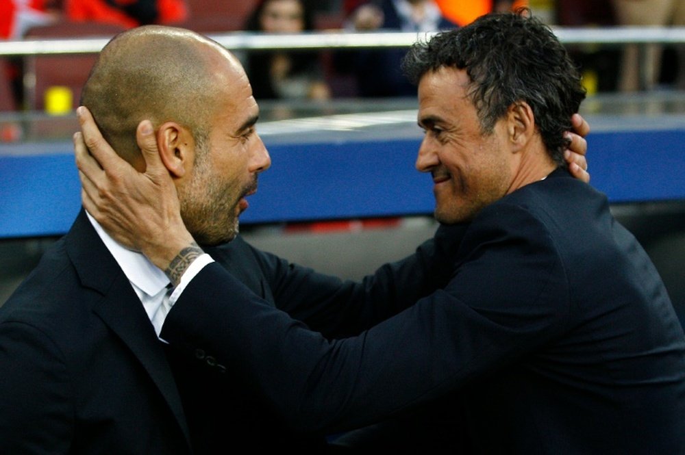 Pep Guardiola and Luis Enrique hugging each other. AFP