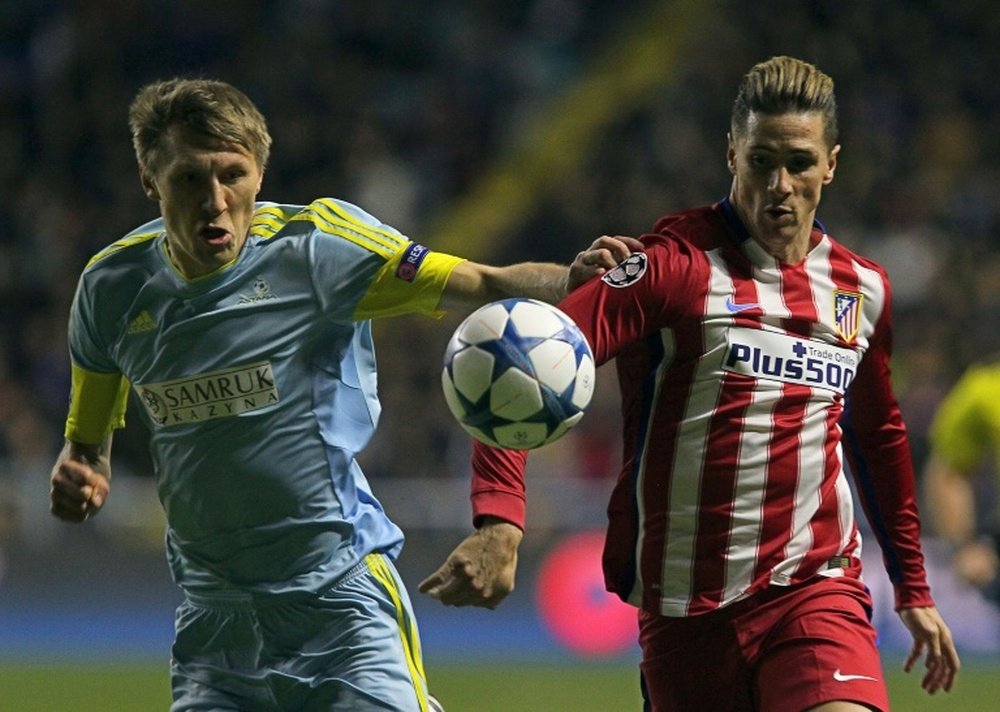 Astanas Kazakh defender Evgeni Postnikov (L) vies for the ball with Atletico Madrids forward Fernando Torres during the UEFA Champions League group C football match at the Astana Arena stadium in Astana on November 3, 2015