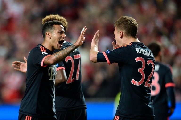 Bayern Munichs Thiago Alcantara (L) celebrates with teammate Joshua Kammich at the end of the UEFA Champions League quarter-final 2nd-leg match against Benfica, at Luz stadium in Lisbon, on April 13, 2016