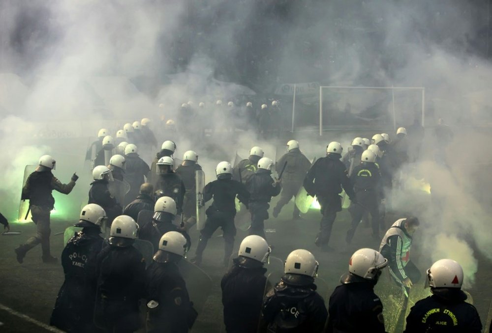 Riot police clashes with fans during a football match between Athens arch-rivals Olympiakos and Panathinaikos on February 22, 2015