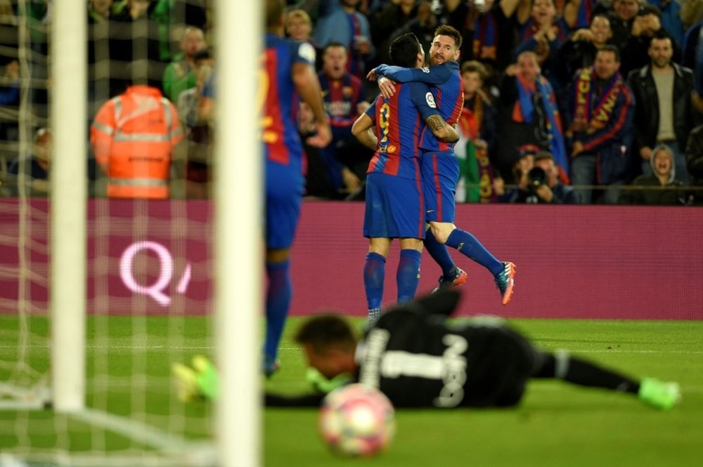 Barcelona's forward Lionel Messi celebrates with Luis Suarez after scoring a goal against Valencia at the Camp Nou stadium in Barcelona on March 19, 2017