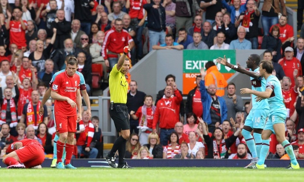 West Ham Uniteds Mark Noble (R) receives a red card from referee Kevin Friend (3rd R) for a challenge on Liverpools Danny Ings (Below L) during an English Premier League football match at Anfield in Liverpool on August 29, 2015