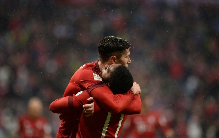 Bayern Munichs striker Robert Lewandowski (L) celebrates a goal with his teammate Douglas Costa during the German first division Bundesliga football match FC Bayern Munich vs TSG 1899 Hoffenheim in Munich, Germany, on January 31, 2016