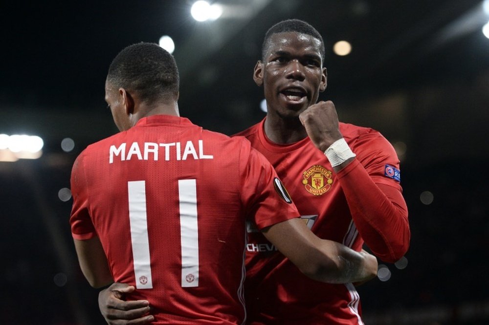 Manchester Uniteds Anthony Martial (L) embraces Paul Pogba as he celebrates scoring their second goal from the penalty spot against Fenerbahce on October 20, 2016
