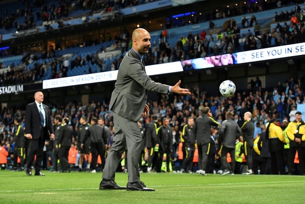 Manchester Citys manager Pep Guardiola plays with a small ball. AFP