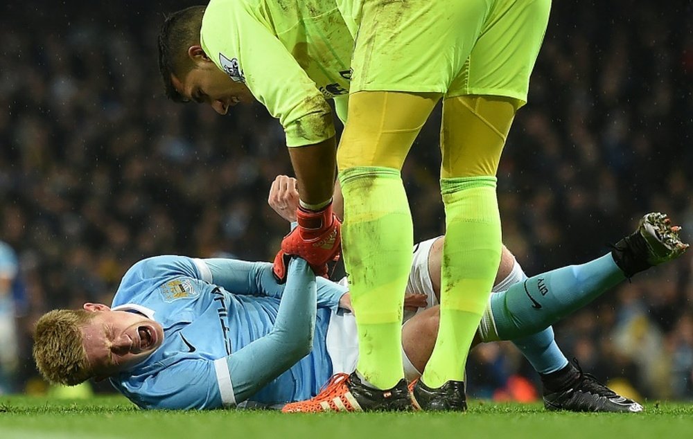 Manchester Citys midfielder Kevin De Bruyne (L) reacts as he talks with Evertons goalkeeper Joel Robles before being stretchered off during an English League Cup semi-final match at the Etihad Stadium in Manchester on January 27, 2016
