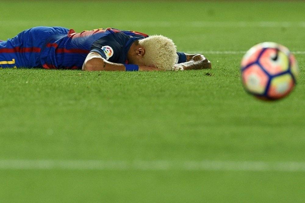 Barcelonas Neymar lies on the pitch after missing a goal during their Spanish La Liga match against Alaves, at the Camp Nou stadium in Barcelona, on September 10, 2016