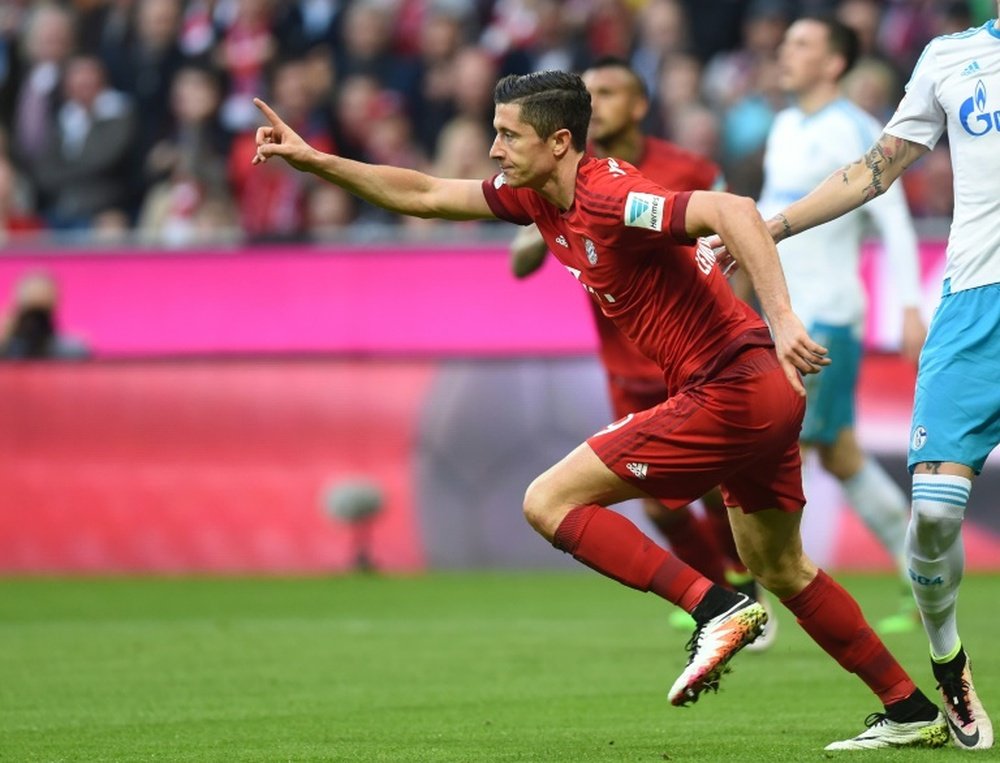 Bayern Munichs striker Robert Lewandowski celebrates scoring during the Bundesliga match against Schalke in Munich, southern Germany on April 16, 2016