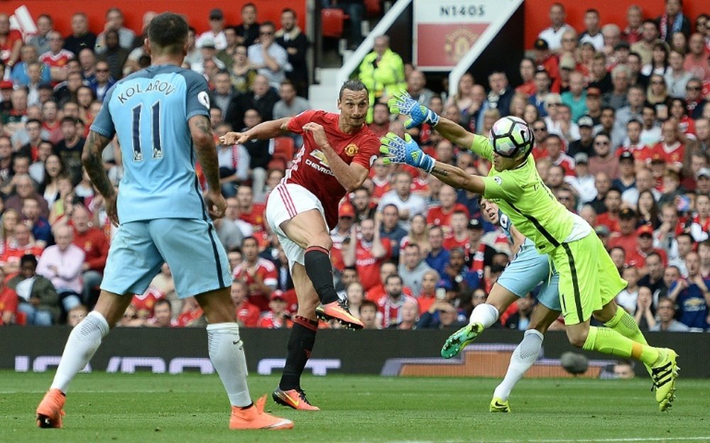 Manchester United striker Zlatan Ibrahimovic (2nd L) shoots past City goalkeeper Claudio Bravo to score their first goal during the English Premier League derby match at Old Trafford in Manchester, north west England, on September 10, 2016