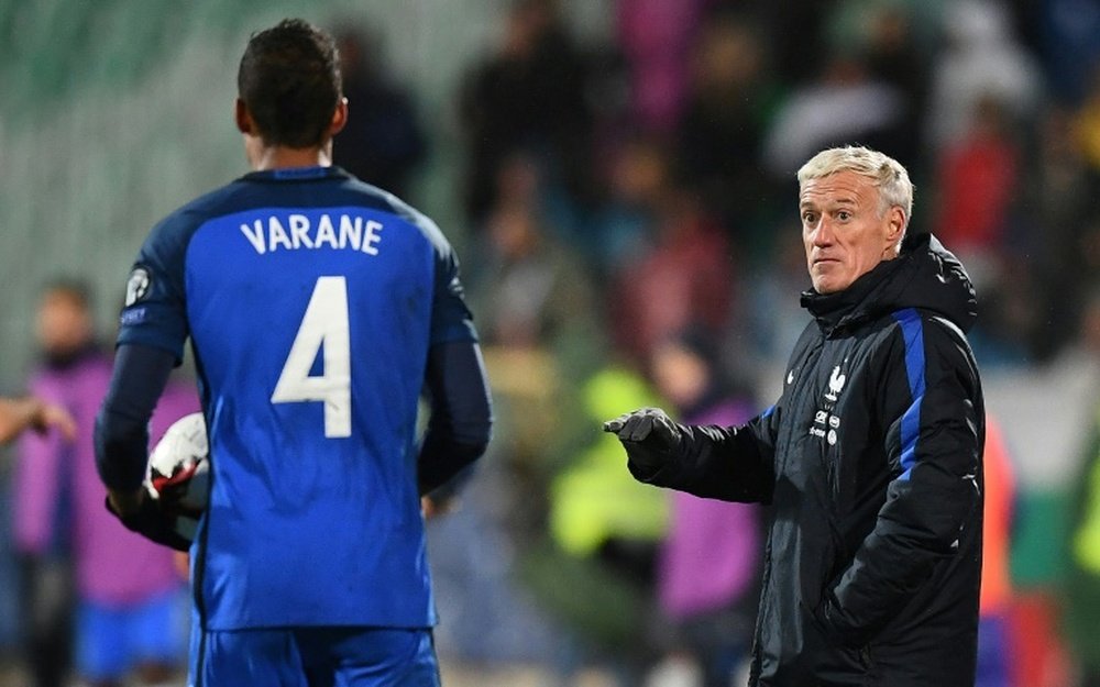 Didier Deschamps parle avec Raphaël Varane lors du match face à la Bulgarie. AFP