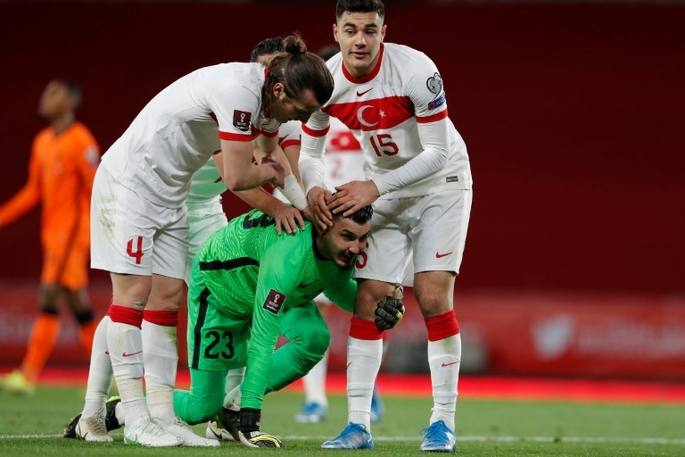Le gardien turc Ugurcan Cakir félicité par ses coéquipiers pour avoir détourné un penalty frappé par l`attaquant neerlandais Memphis Depay lors du match de qualification pour le Mondial 2022, à Istanbul, le 24 mars 2021