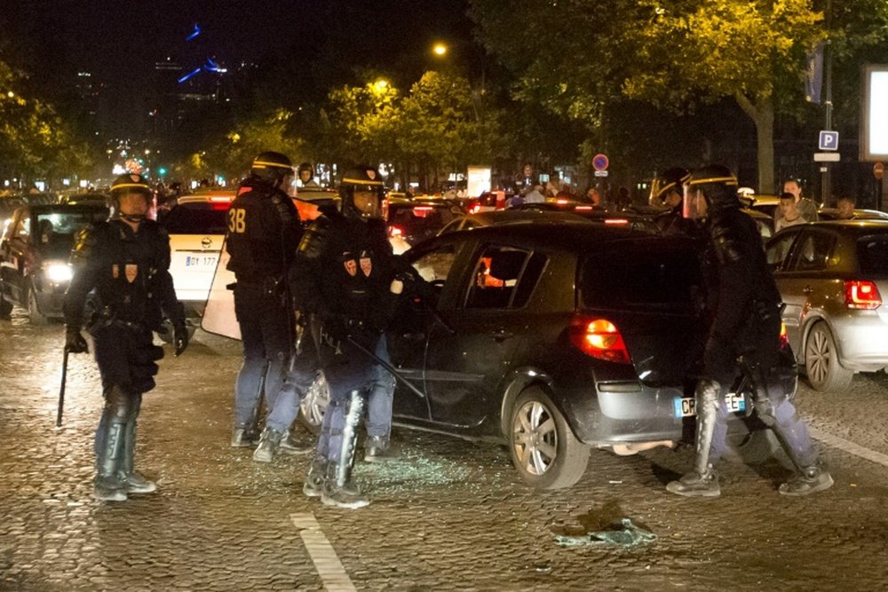 Des CRS en intervention sur les Champs-Elysées à Paris, après la victoire des Bleus à l'Euro. AFP