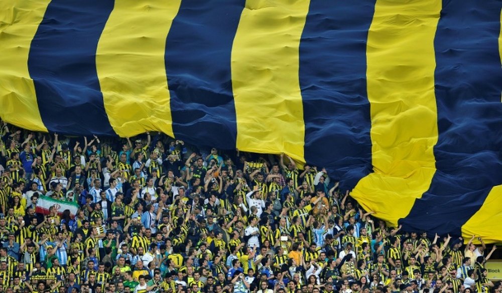 Des supporters de Fenerbahçe avec un drapeau géant lors du match face au rival Galatasaray. AFP