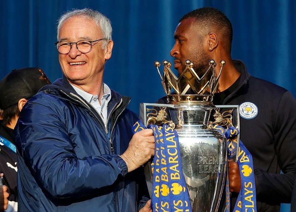 Lentraîneur de Leicester City, Claudio Ranieri (g) brandit le trophée de champion dAngleterre de football après la parade, à Victoria Park, le 16 mai 2016