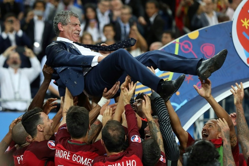 Le sélectionneur portugais Fernando Santos, porté en triomphe par ses joueurs après la victoire, 1-0 face à la France, en finale de l'Euro, le 10 juillet 2016 au Stade de France à Saint-Denis