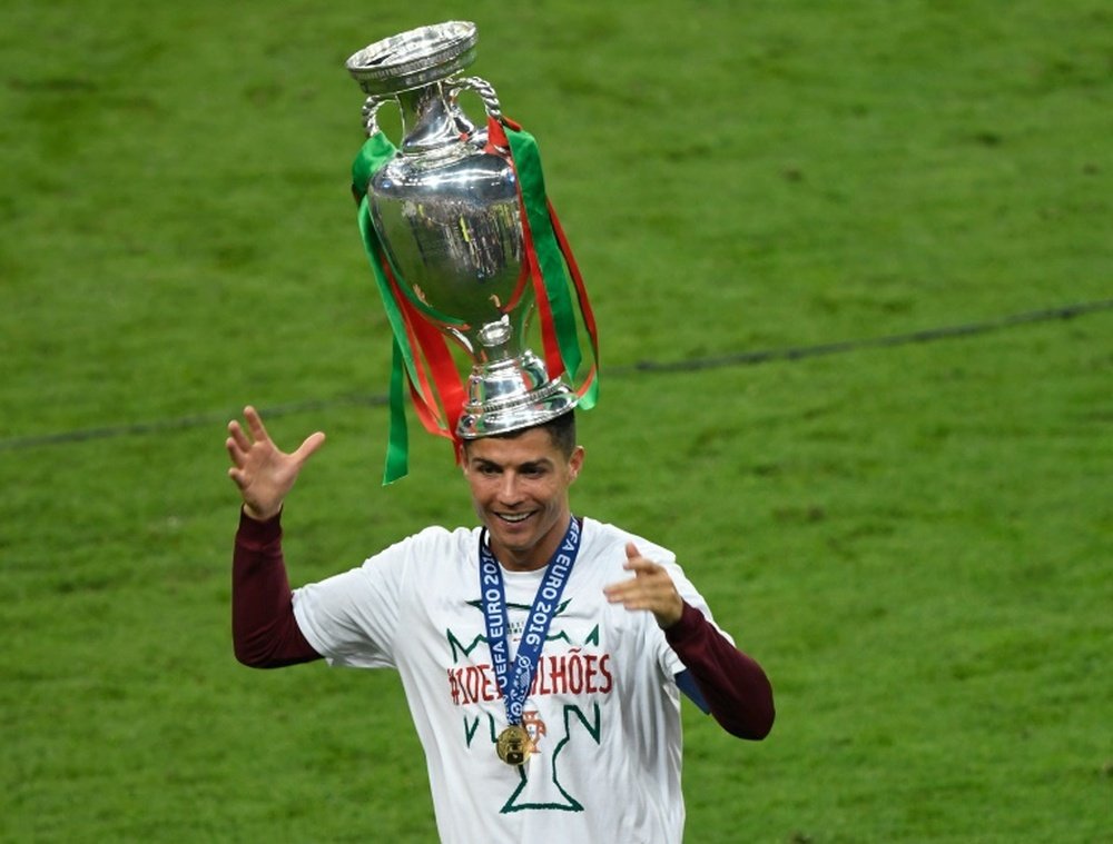 La star du Portugal Cristiano Ronaldo pose avec le trophée de l'Euro 2016, après la victoire de son équipe en finale, à Saint-Denis, le 10 juillet 2016