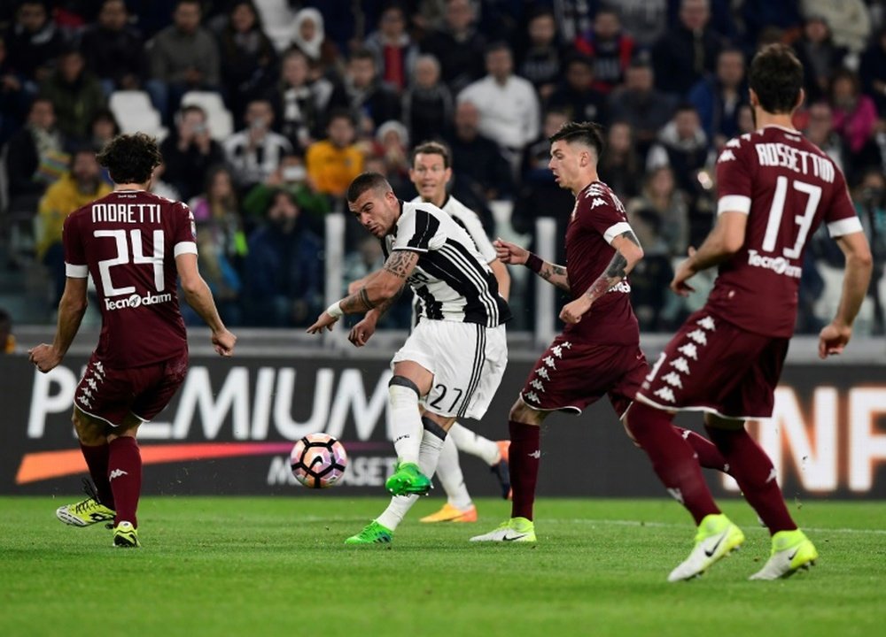 Le milieu de la Juventus Stefano Sturaro (c) dégage le ballon lors du match face au Torino. AFP