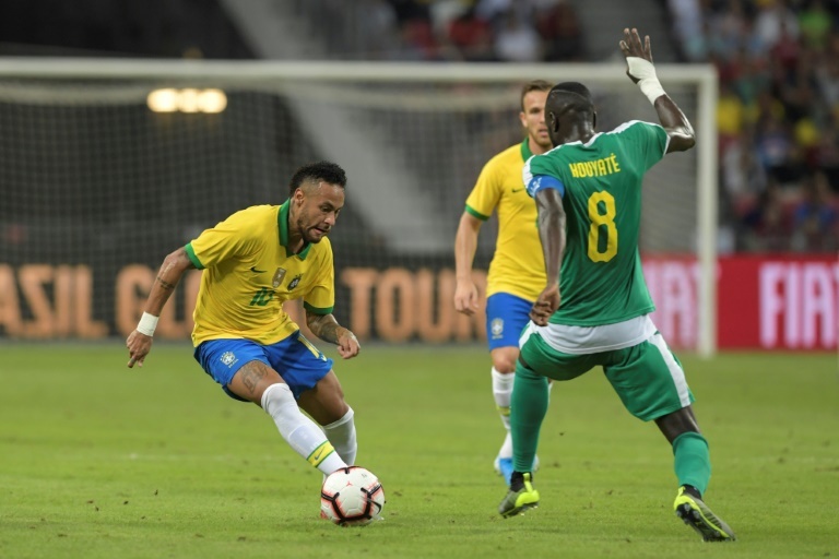 Neymar trata de regatear a dos defensas de Senegal durante el amistoso en Singapur.