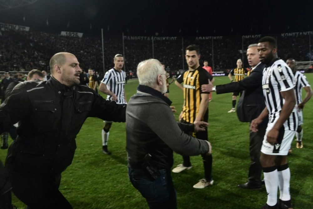 Le président du PAOK, arme à la ceinture, envahit le terrain. AFP