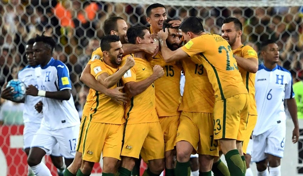Os jogadores da Austrália rodeiam o seu capitão em acesa celebração. AFP