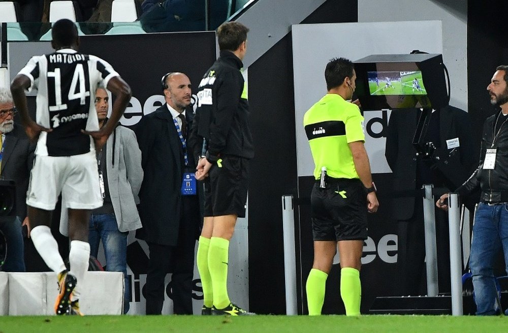 L'arbitre Doveri se sert de la vidéo pour juger une situation lors du match Juventus-Fiorentina. AFP