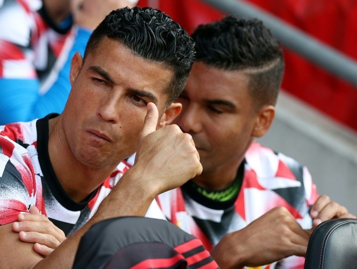 Cristiano sentado com Casemiro no banco de reservas do Manchester United.AFP
