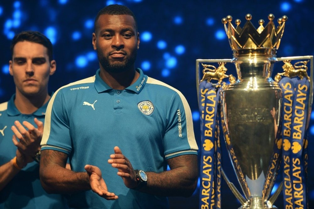 Le défenseur et capitaine de Leicester Wes Morgan, à côté du trophée de la Premier League anglaise, à Bangkok, le 18 mai 2016