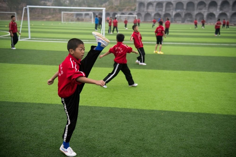 Échauffement avant un match de football à l'école d'arts martiaux Tagou à Dengfeng en Chine. AFP