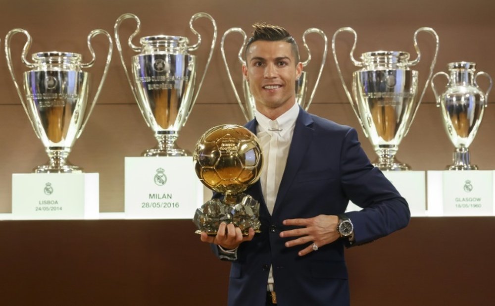 Cristiano Ronaldo pose avec le Ballon 2016 dans la salle des Trophées du Real. AFP