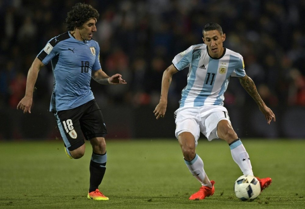 L'Argentin Di Maria à la lutte avec l'Uruguayen Ramirez en match de qualifications. AFP
