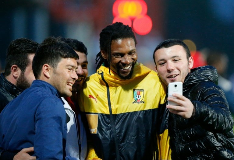 Rigobert Song poses for photographs with fans. AFP