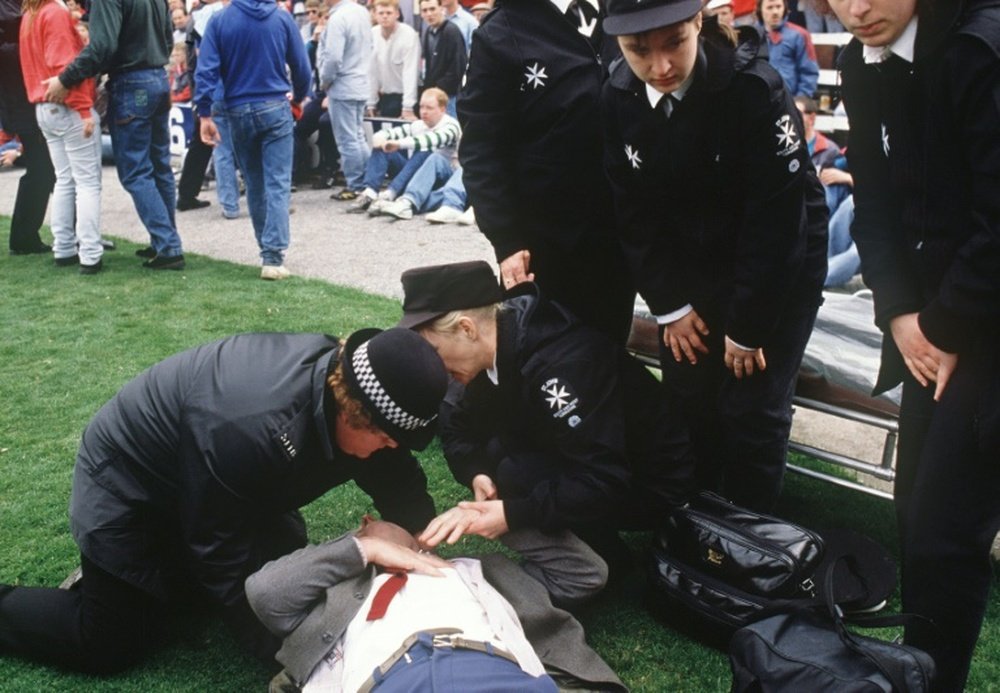Le service médical et un blessé sur la pelouse du stade de Hillsborough, le 15 avril 1989. AFP