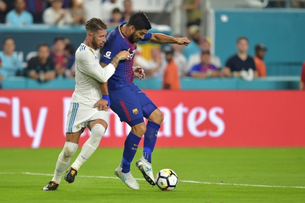 L'attaquant du Barça Luis Suarez à la lutte avec Sergio Ramos, le capitaine du Real Madrid. AFP