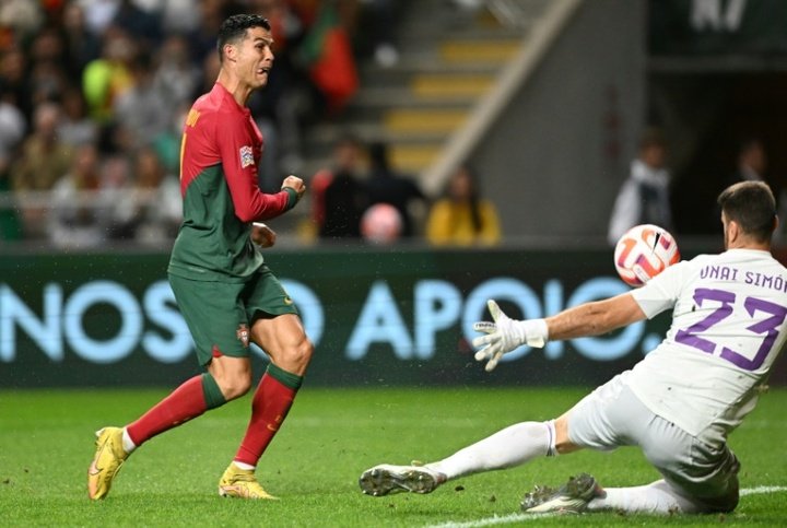 Cristiano Ronaldo encarando ao goleiro espanhol Unai Simon em dividida pela Liga das Nações.AFP