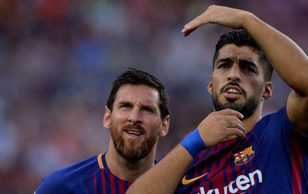 Messi e Suárez torcem pela chegada de um jogador ao Barcelona. AFP