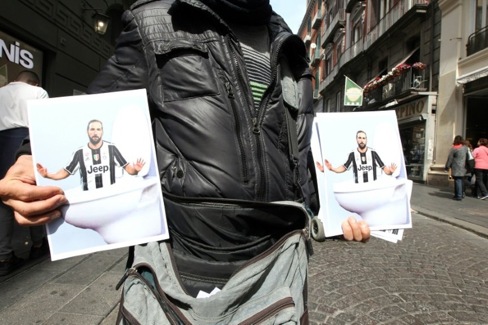 Des posters mettant en scène Gonzalo Higuain dans une cuve de WC, vendus dans une rue de Naples. AFP