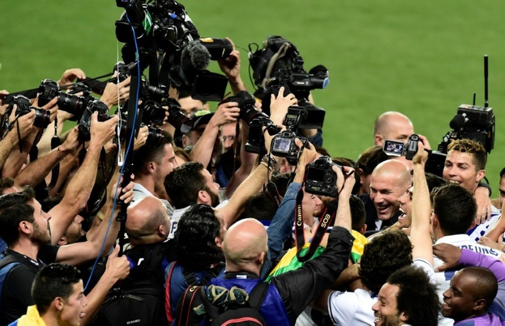 L'entraîneur du Real Zidane entouré de photographes après le titre de champion d'Espagne. AFP