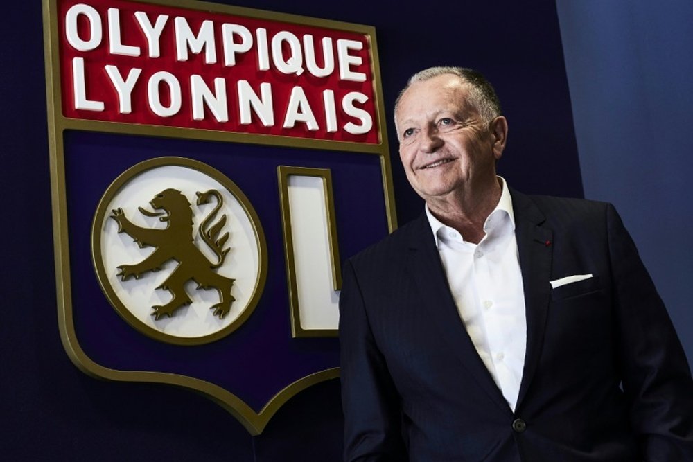 Jean-Michel Aulas pose devant le logo de l'Olympique Lyonnais. AFP