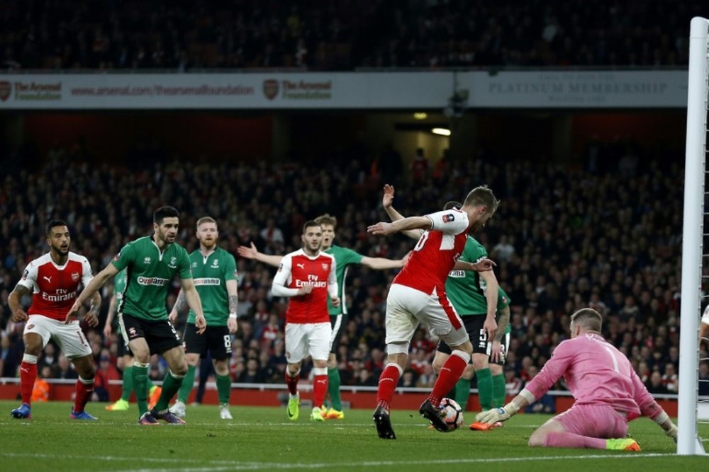 Aaron Ramsey dribble le gardien de Lincoln City Paul Farman pour marquer le 5e but d'Arsenal. AFP