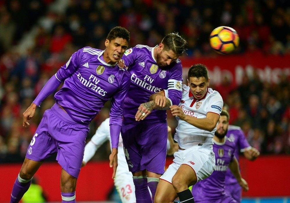 Le defenseur du Real Madrid Sergio Ramos (c) marque de la tête contre son camp face à Séville. AFP