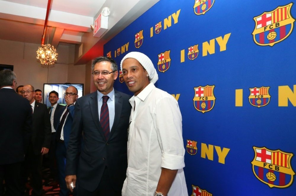 Ronaldinho standing next to BArcelona's president Josep Maria Bartomeu. AFP