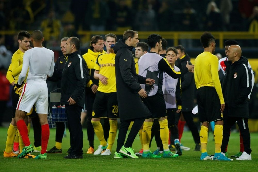 Les joueurs de Monaco (blanc) et de Dortmund se congratulent à la fin du match de C1 reporté. AFP