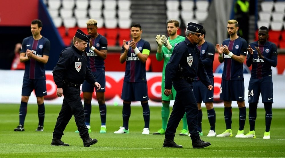 Hommage rendu par les joueurs du PSG et de Montpellier au policier tué. AFP