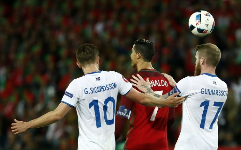 Lattaquant portugais Cristiano Ronaldo, marqué de près par les Islandais Gylfi Sigurdsson et Aron Gunnarsson lors de lEuro, le 14 juin 2016 à Saint-Etienne