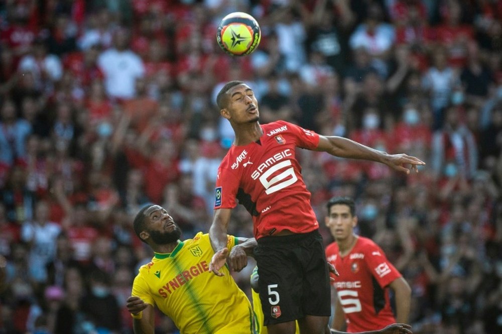 Le défenseur rennais Loïc Badé dégage le ballon devant l`attaquant nantais Marcus Coco, lors de leur match de Ligue 1, le 22 août 2021 au Roazhon Park Stadium