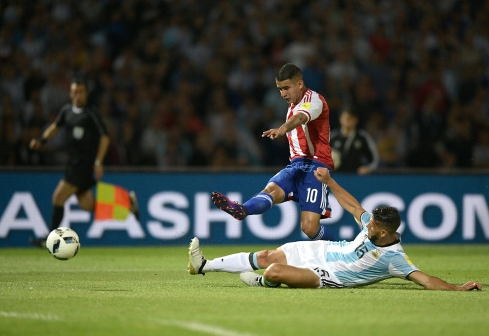 Le Paraguayen Gonzalez tir au but face à l'Argentin Demichelis en qualifs pour le Mondial-2018. AFP