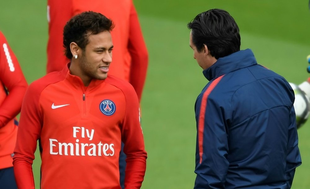 La star brésilienne du PSG Neymar Jr échange avec son coach Unai Emery. AFP