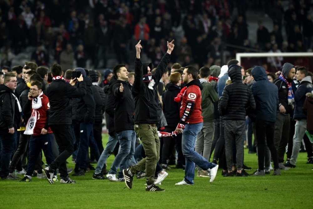 Des supporters lillois mécontents, sur la pelouse, à l'issue du match contre Montpellier. AFP