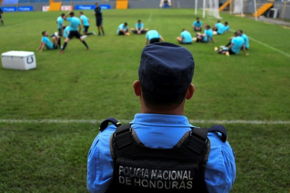 Un membre de la police hondurienne surveille l'entraînement de l'équipe d'Australie. AFP