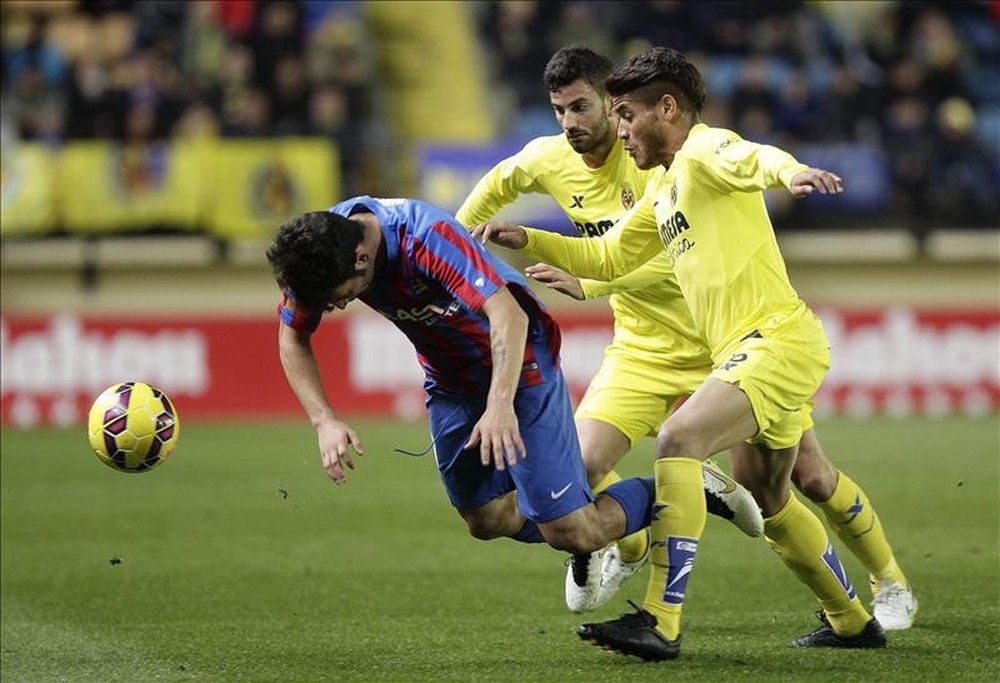 El centrocampista del Levante Rubén García (i) cae tras la entrada del mexicano Jonathan Dos Santos (d), del Villarreal, durante un partido de Liga. EFE/Archivo